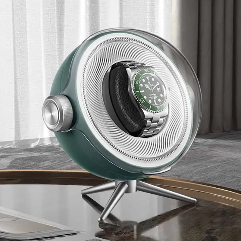 Modern watch winder with silver green accents and a stainless steel wristwatch on display table