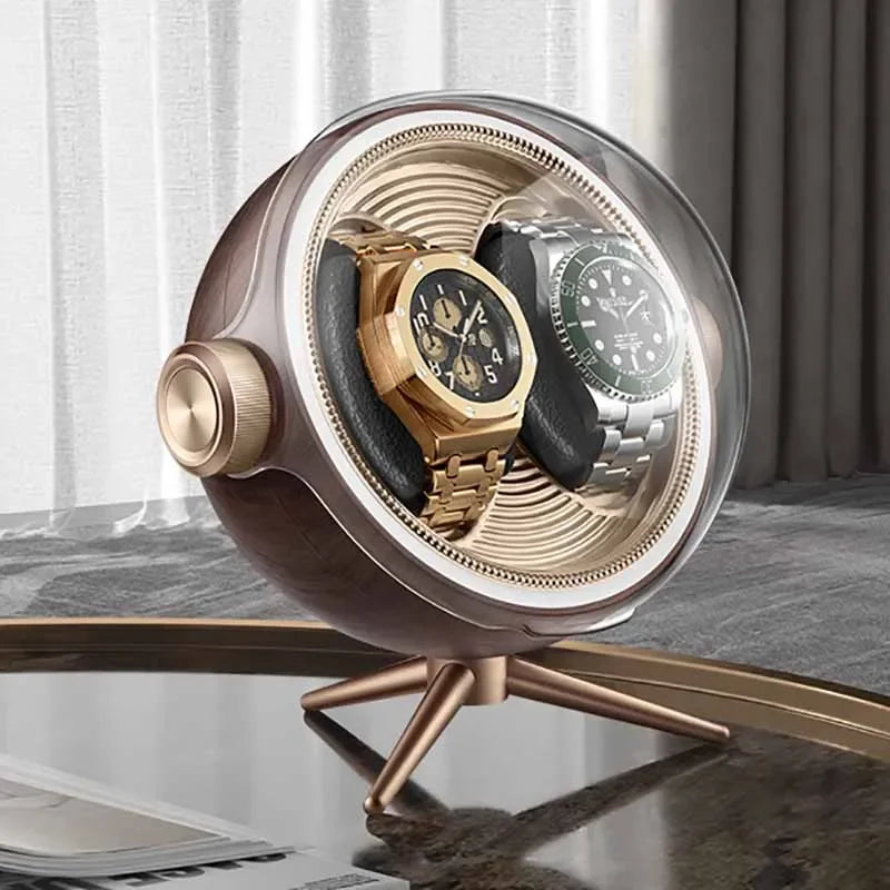 Modern watch winder case with two luxury wristwatches displayed on a glass table.