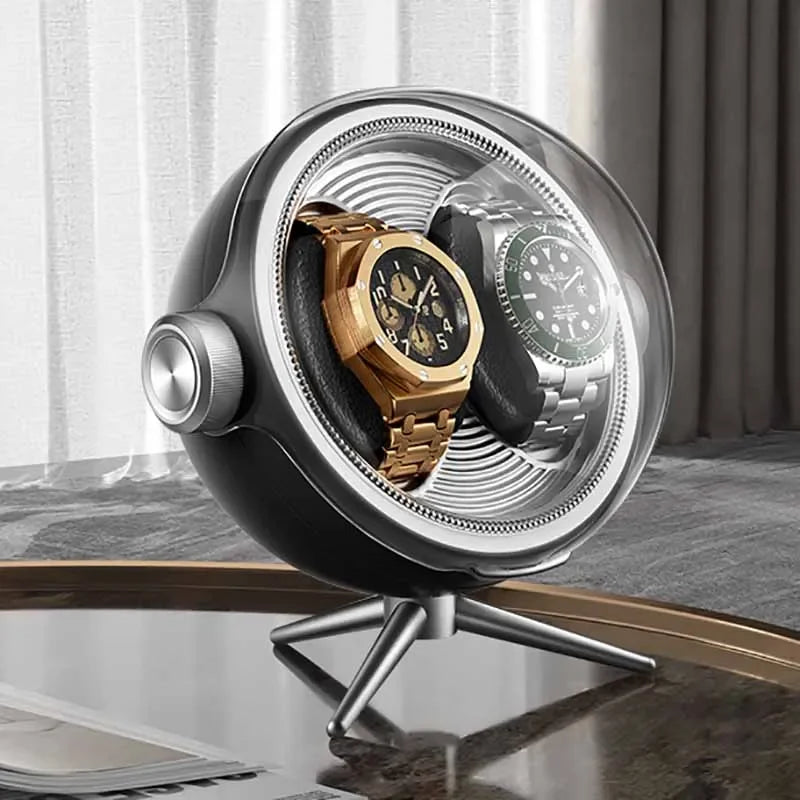 Modern dual watch winder with gold and silver luxury watches on a table