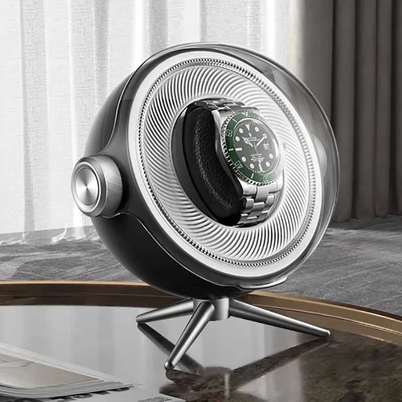 Modern automatic watch winder with stainless steel case on a table, luxury watch inside